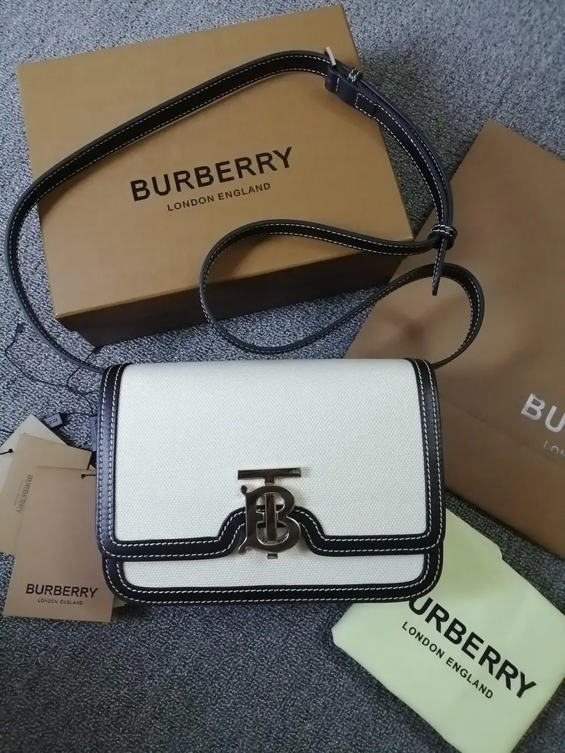BHome.TBThe little two-colour diagonal leather locking bag., A one-hand bag with a copy., Lock button decoration Thomas Bur Inspired Special Identification. Switch to slanted backpack or hand-held bag. Numbering: 90235 Dimensions:21 - 16 - 6cm. 86488010