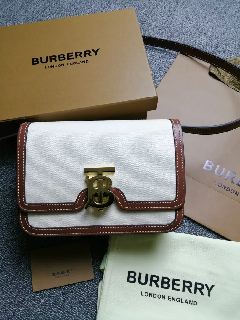 BHome.TBThe little two-colour diagonal leather locking bag., A one-hand bag with a copy., Lock button decoration Thomas Bur Inspired Special Identification. Switch to slanted backpack or hand-held bag. Numbering: 90235 Dimensions:21 - 16 - 6cm. 86488010