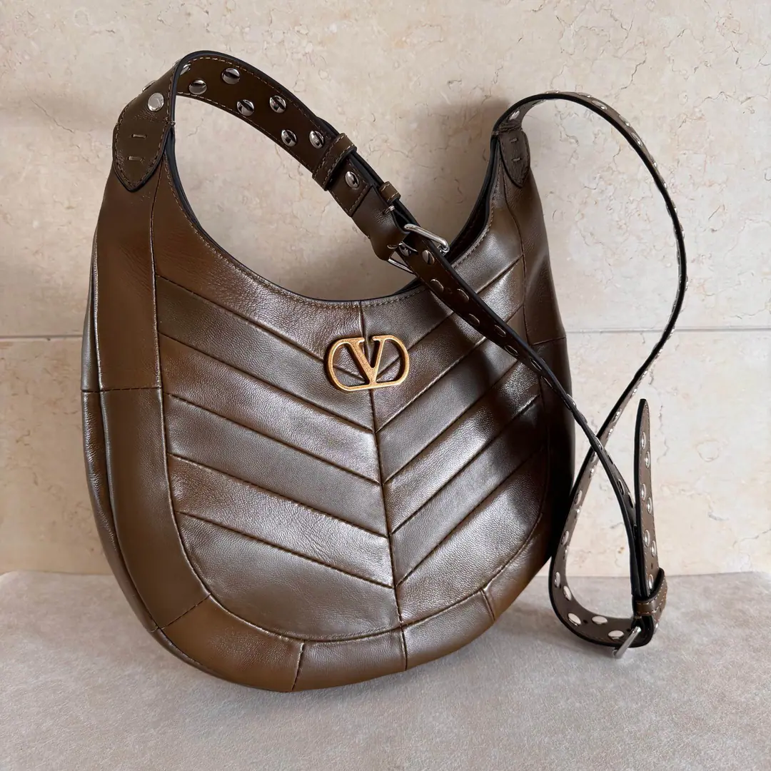 Small. Valentino.GARAVANI HOBOHO HOBO Handbags are designed in a synthesizing system., It's made of bright and dumb sheep leather. V Font, And used to treat it with a copy of the old brass. VLOGO SIGNATURE Metal Details. This bag is equipped with a regressable shoulder belt., But the shoulder can slash.. Regulating leather shoulder belts, Pride, nail. Size of the trumpet: 28X 21.5X 3centimetres Model: 2026