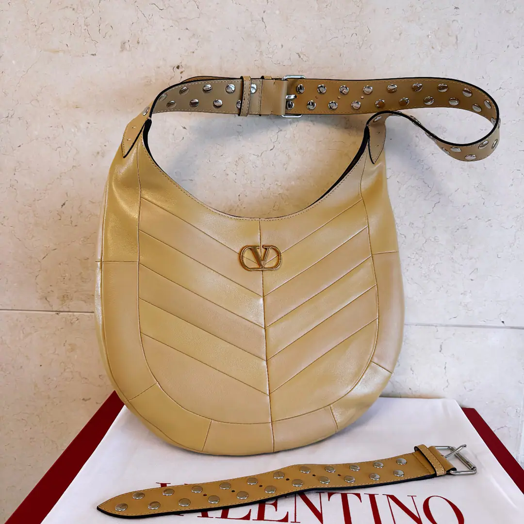 Large. Valentino.GARAVANI HOBOHO HOBO Handbags are designed in a synthesizing system., It's made of bright and dumb sheep leather. V Font, And used to treat it with a copy of the old brass. VLOGO SIGNATURE Metal Details. This bag is equipped with a regressable shoulder belt., But the shoulder can slash.. Regulating leather shoulder belts, Pride, nail. Large size: 35 X 27 X 4 centimetres Model: 2026