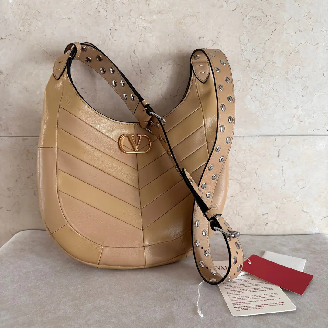Small. Valentino.GARAVANI HOBOHO HOBO Handbags are designed in a synthesizing system., It's made of bright and dumb sheep leather. V Font, And used to treat it with a copy of the old brass. VLOGO SIGNATURE Metal Details. This bag is equipped with a regressable shoulder belt., But the shoulder can slash.. Regulating leather shoulder belts, Pride, nail. Size of the trumpet: 28X 21.5X 3centimetres Model: 2026
